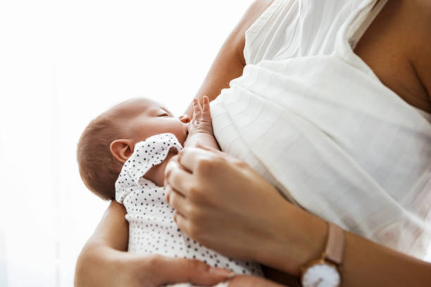 a woman in white breastfeeding her baby