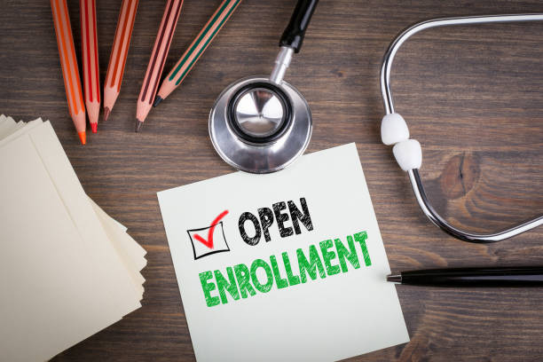 a piece of paper that says "open enrollment" on top of a doctors desk